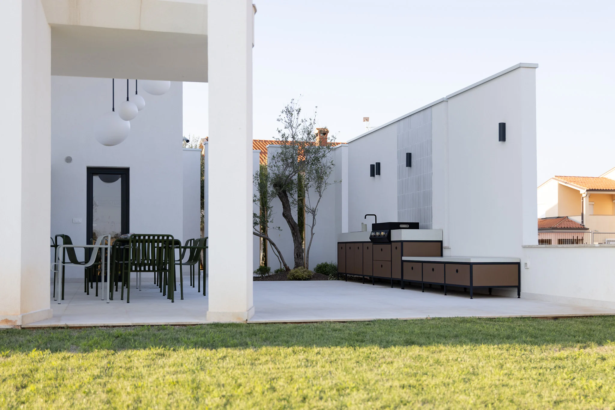 Cucina POP, terrazza da pranzo e prato presso una casa contemporanea a Umag